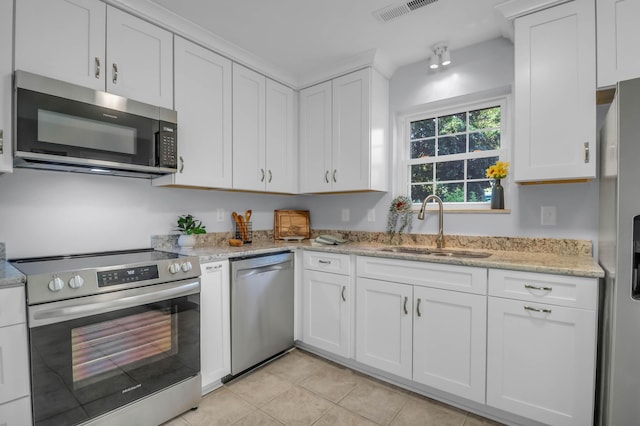 kitchen with stainless steel appliances, a sink, white cabinets, and light tile patterned floors