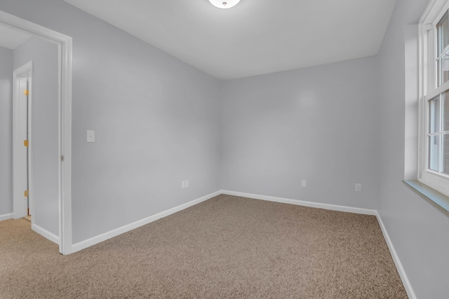 carpeted empty room with baseboards