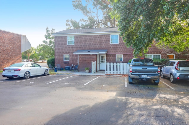view of front of home with uncovered parking and brick siding