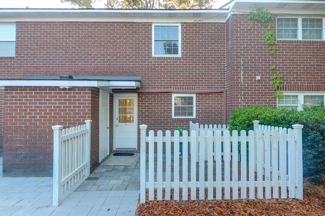 ranch-style house featuring fence, brick siding, and a patio