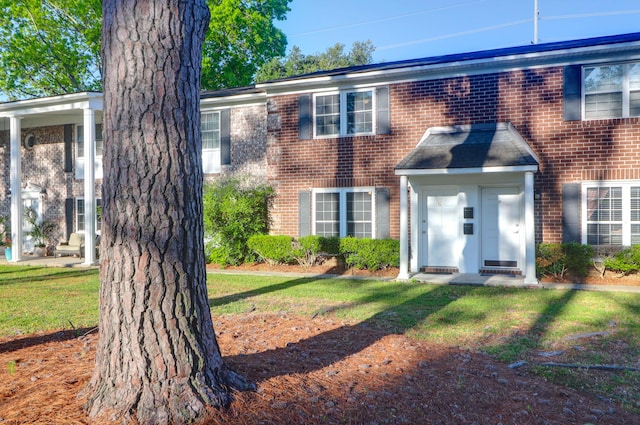 view of front of home with brick siding and a front yard