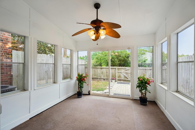 unfurnished sunroom featuring carpet floors and lofted ceiling