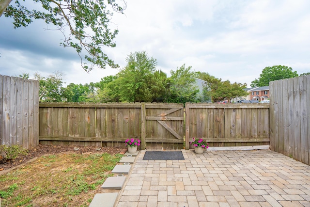 fenced backyard featuring a gate and a patio