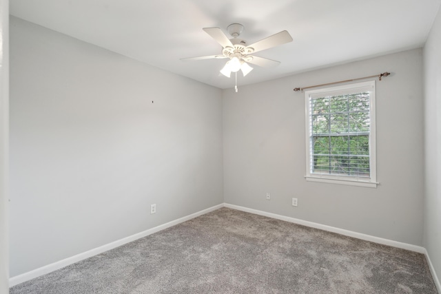 carpeted spare room with baseboards and a ceiling fan