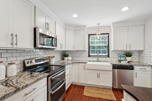 kitchen with stainless steel appliances, a sink, dark wood-type flooring, and white cabinetry