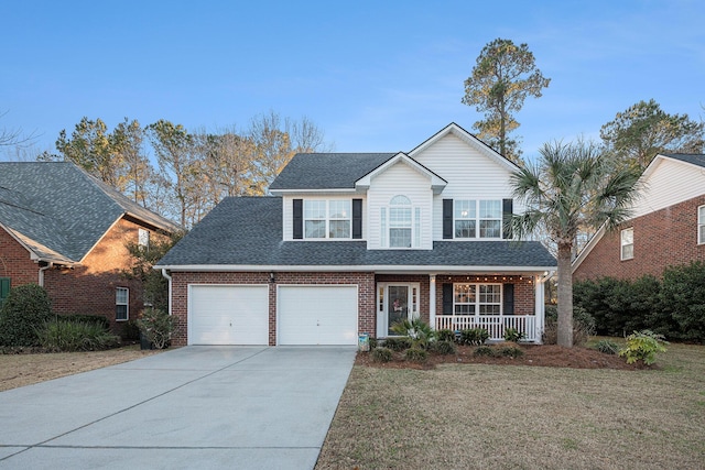 view of front of house featuring a porch, a garage, and a front yard