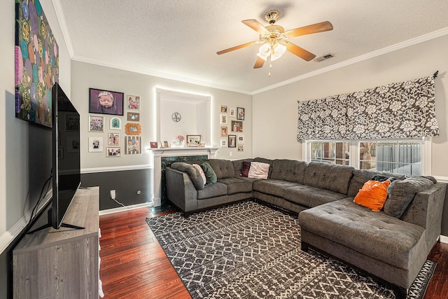 living room featuring a textured ceiling, dark hardwood / wood-style flooring, and ornamental molding