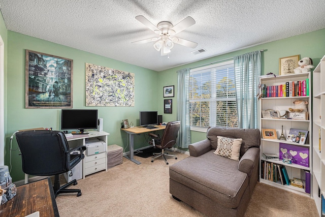 office space with a textured ceiling, carpet floors, and ceiling fan