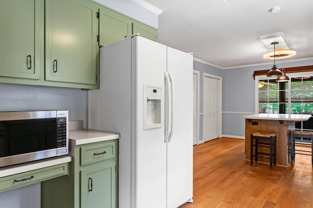 4075 Brown St, Orangeburg, SC 29118 - kitchen with green cabinetry, stainless steel microwave, light countertops, light wood finished floors, and crown molding