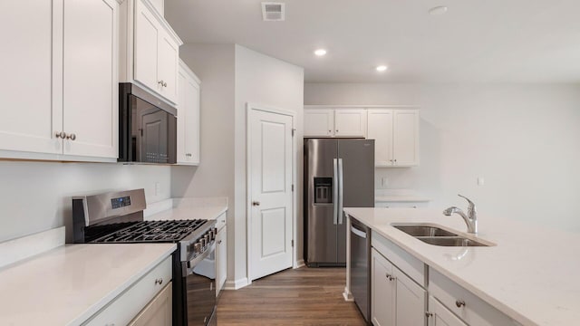 kitchen featuring stainless steel appliances, sink, dark wood-type flooring, and white cabinets