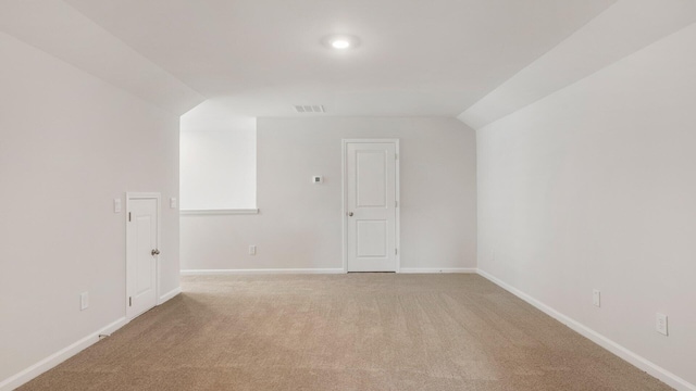 bonus room with lofted ceiling and light carpet