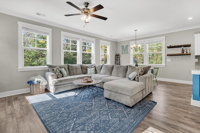 living room with crown molding, hardwood / wood-style flooring, and ceiling fan with notable chandelier