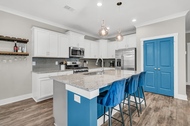 kitchen featuring hardwood / wood-style floors, sink, white cabinetry, and stainless steel appliances