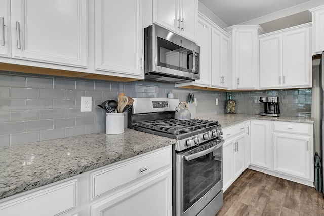 kitchen with stainless steel appliances, light stone countertops, tasteful backsplash, white cabinets, and dark hardwood / wood-style flooring