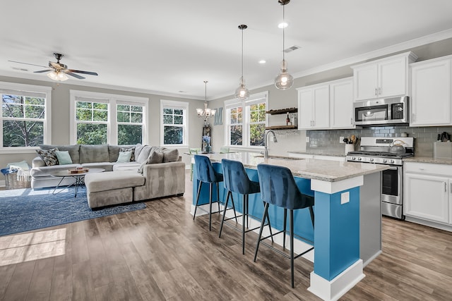 kitchen featuring appliances with stainless steel finishes, sink, decorative light fixtures, and white cabinets