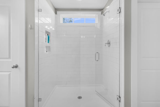 bathroom with a shower with door