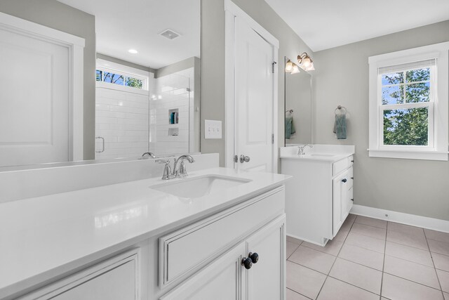 bathroom featuring vanity, a shower with shower door, plenty of natural light, and tile patterned flooring