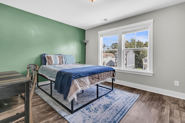 bedroom with dark hardwood / wood-style flooring