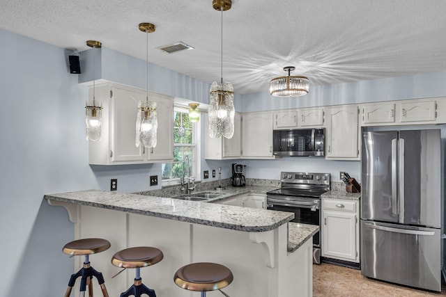 2773 Forest Dew Ct, Charleston, SC 29414 - kitchen with appliances with stainless steel finishes, a peninsula, a textured ceiling, white cabinets, and a kitchen breakfast bar