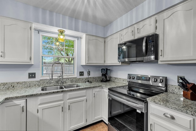 2773 Forest Dew Ct, Charleston, SC 29414 - kitchen with stainless steel electric range, black microwave, white cabinets, light tile patterned flooring, and light stone countertops