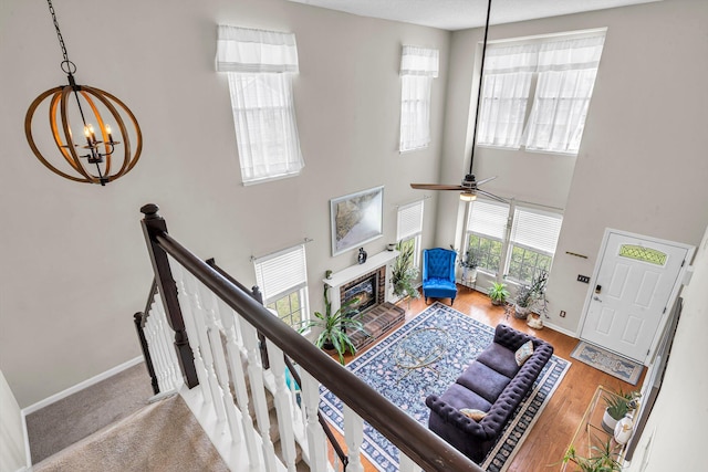 2773 Forest Dew Ct, Charleston, SC 29414 - living area featuring a chandelier, a glass covered fireplace, a high ceiling, a ceiling fan, and wood finished floors