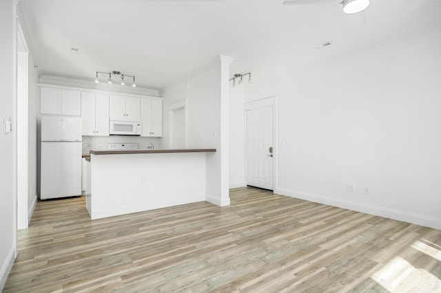 kitchen with white appliances, white cabinetry, light hardwood / wood-style floors, decorative backsplash, and ceiling fan