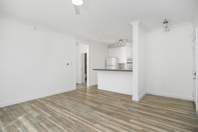 unfurnished living room with ceiling fan, rail lighting, crown molding, and light hardwood / wood-style floors