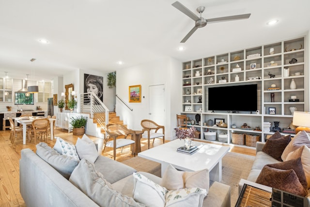 living room with light hardwood / wood-style floors and ceiling fan