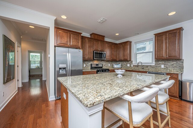 1607 Roustabout Way, Charleston, SC 29414 - kitchen with stainless steel appliances, a kitchen island, plenty of natural light, tasteful backsplash, and ornamental molding
