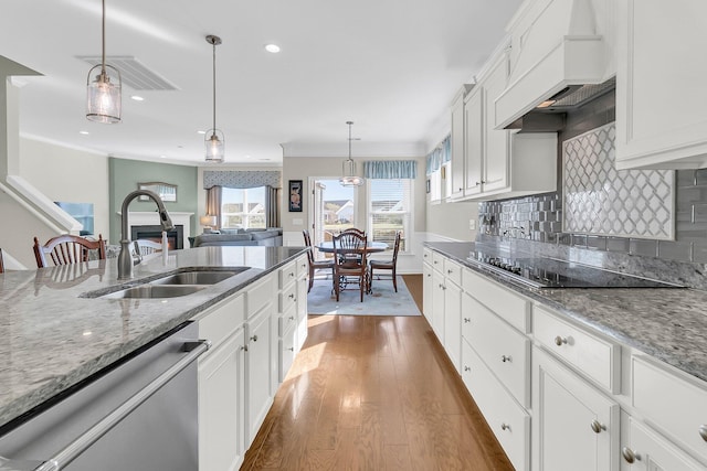 kitchen with custom range hood, a sink, tasteful backsplash, black electric cooktop, and dishwasher