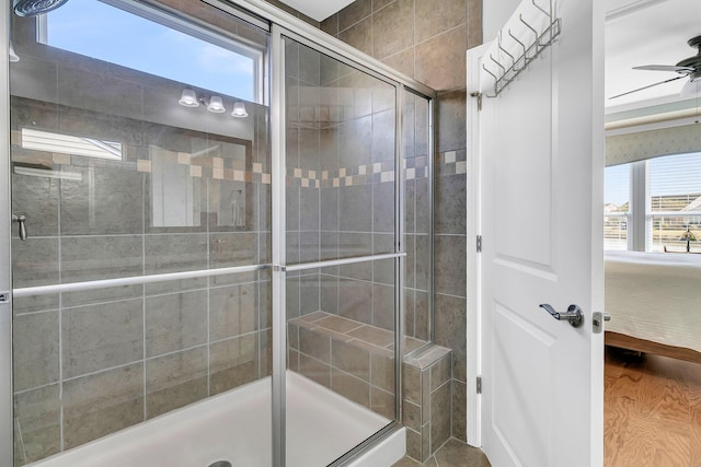 bathroom featuring a shower stall, connected bathroom, a healthy amount of sunlight, and ceiling fan