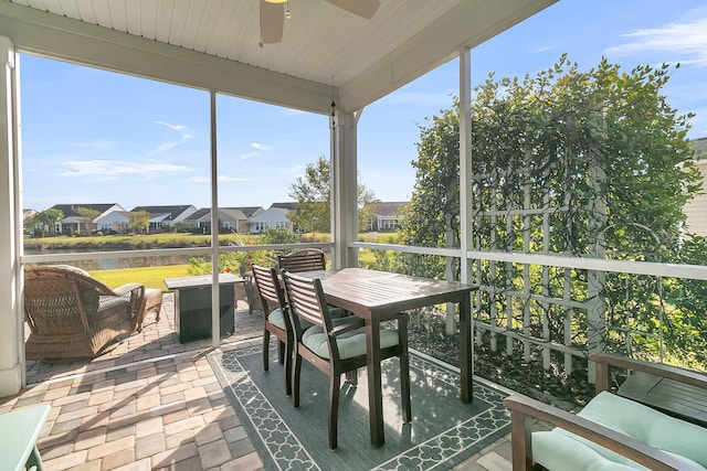 sunroom / solarium featuring a ceiling fan