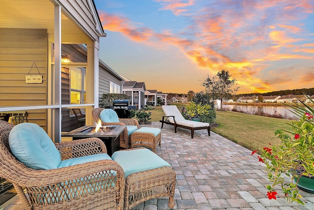 patio terrace at dusk with a fire pit and a lawn