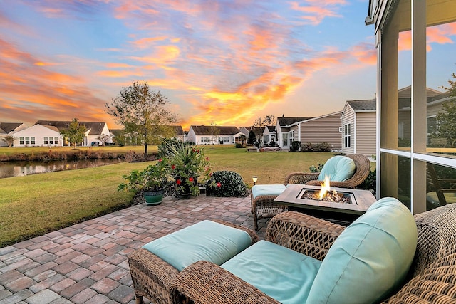 view of patio / terrace with a residential view, a fire pit, and a water view