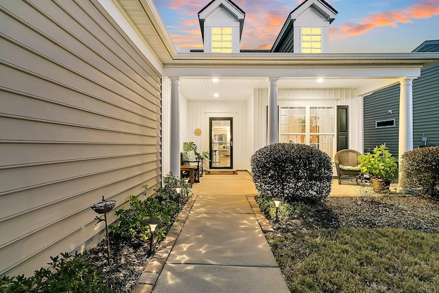 exterior entry at dusk featuring covered porch