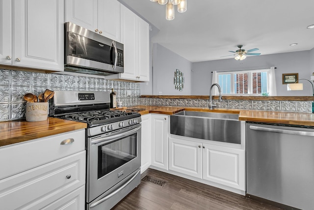 kitchen featuring white cabinets, butcher block countertops, and appliances with stainless steel finishes