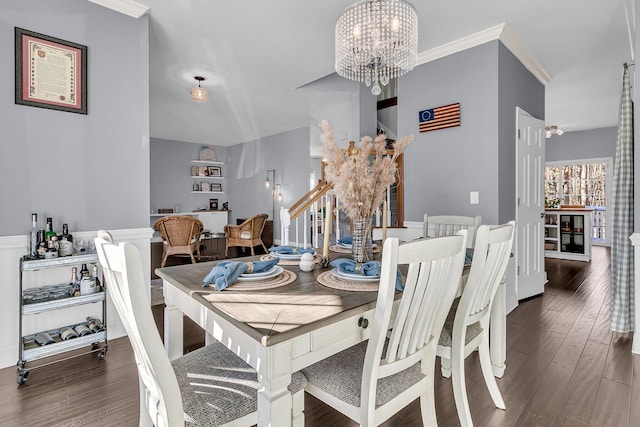 dining room with dark hardwood / wood-style floors, crown molding, and an inviting chandelier