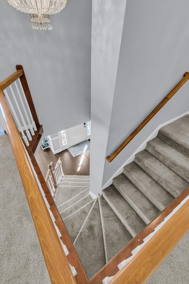 stairway featuring a chandelier and carpet