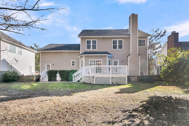 rear view of house with a wooden deck and a yard