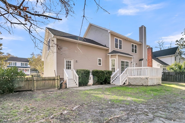 rear view of house with a deck and a yard