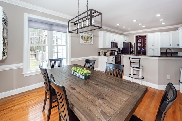 dining area with light wood-type flooring, crown molding, baseboards, and recessed lighting