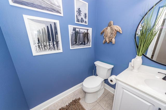 half bath with tile patterned flooring, baseboards, vanity, and toilet