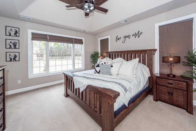 bedroom featuring baseboards, a raised ceiling, visible vents, and light colored carpet