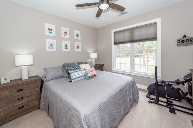 bedroom with light carpet, ceiling fan, visible vents, and baseboards