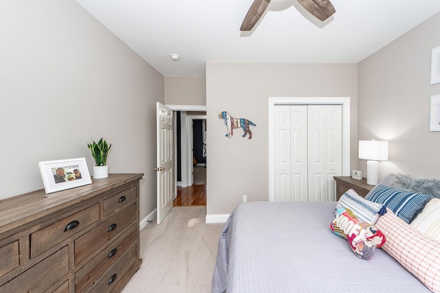 bedroom with a ceiling fan, baseboards, a closet, and light colored carpet