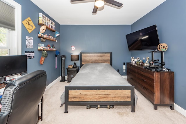 bedroom with light colored carpet, ceiling fan, and baseboards