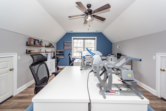 office space featuring baseboards, vaulted ceiling, and light wood finished floors