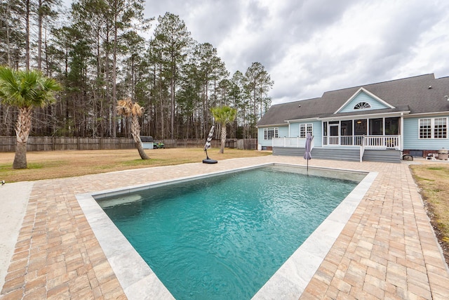 view of pool with a fenced in pool, a yard, a sunroom, a patio area, and fence