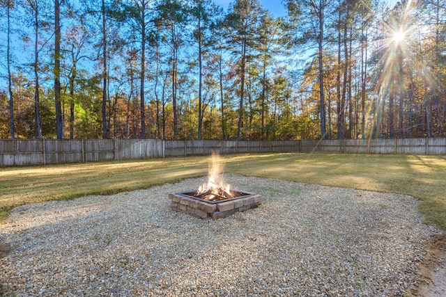 view of yard with an outdoor fire pit and fence