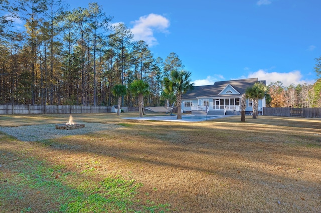 view of yard featuring an outdoor fire pit and fence